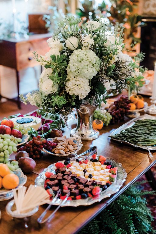 Charcuterie boards and appetizers arranged on a dining table with floral centerpiece