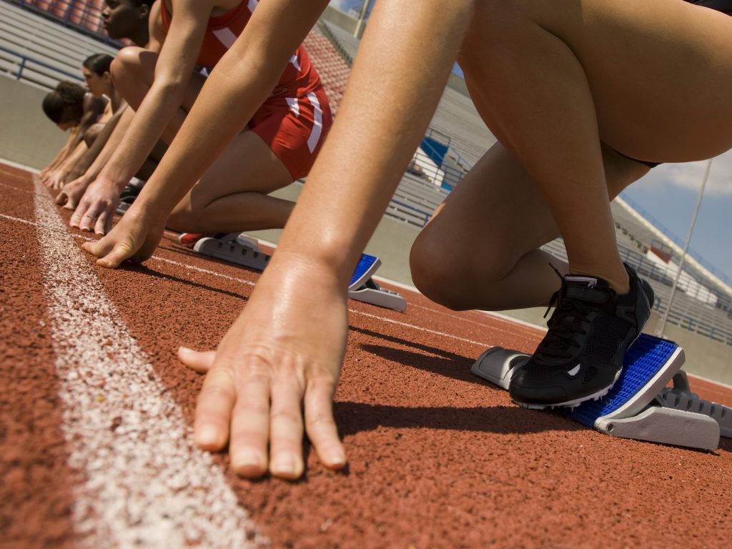 Young women runners at the starting blocks