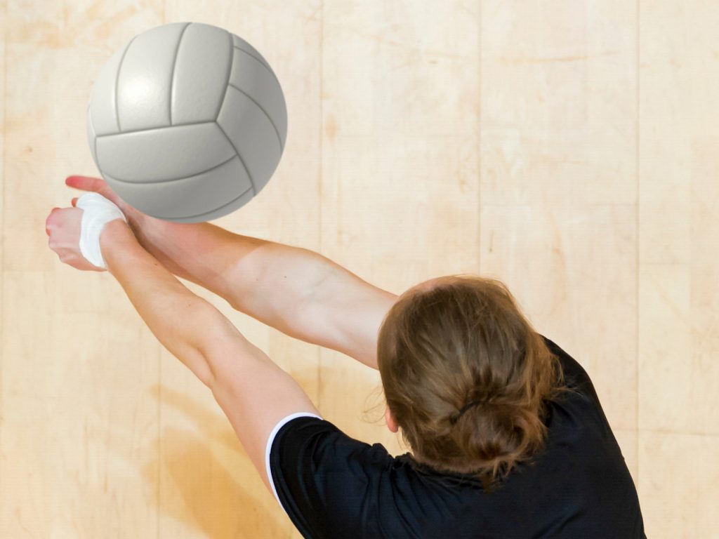 Young woman diving to hit a volleyball