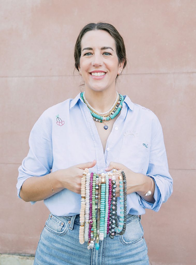 artist holding beaded necklaces