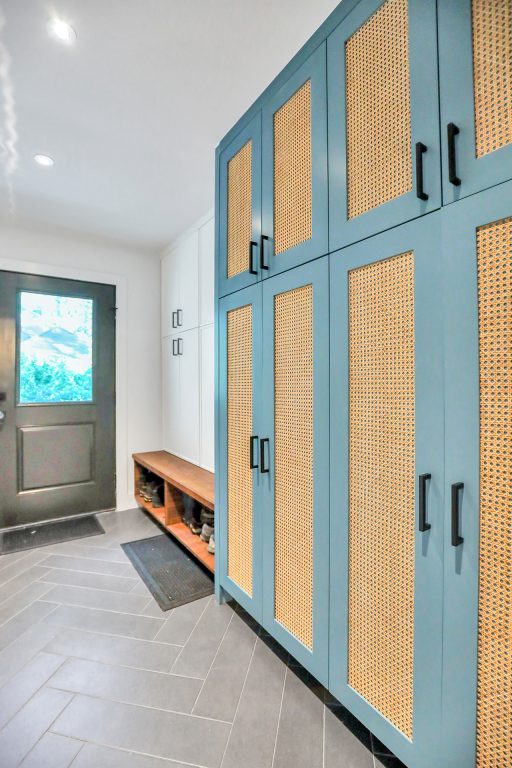 Textured storage cabinets in a hallway with a gray herringbone tile floor