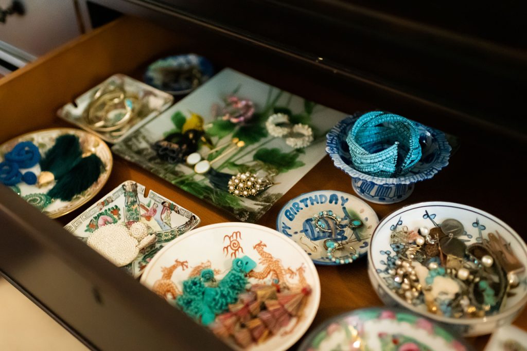 Jewelry organized in small dishes inside a dresser drawer