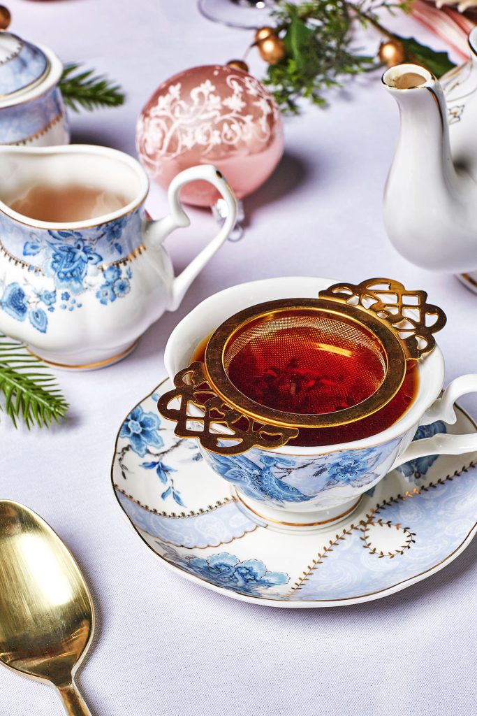 Strainer in tea cup painted with blue flowers