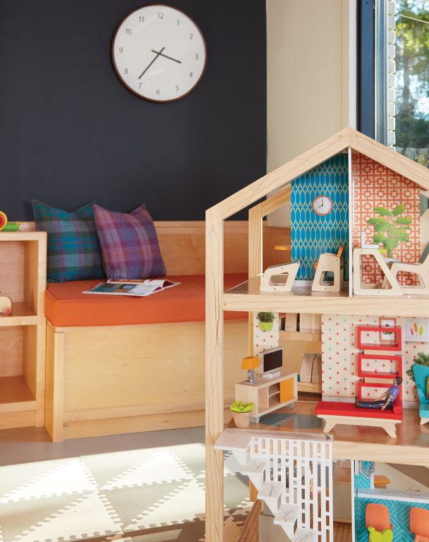 Wooden dollhouse in a child's colorful playroom