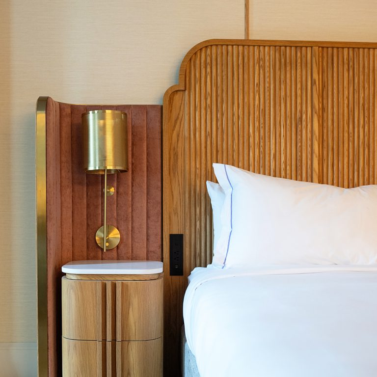 A headboard and nightstand in an upscale hotel