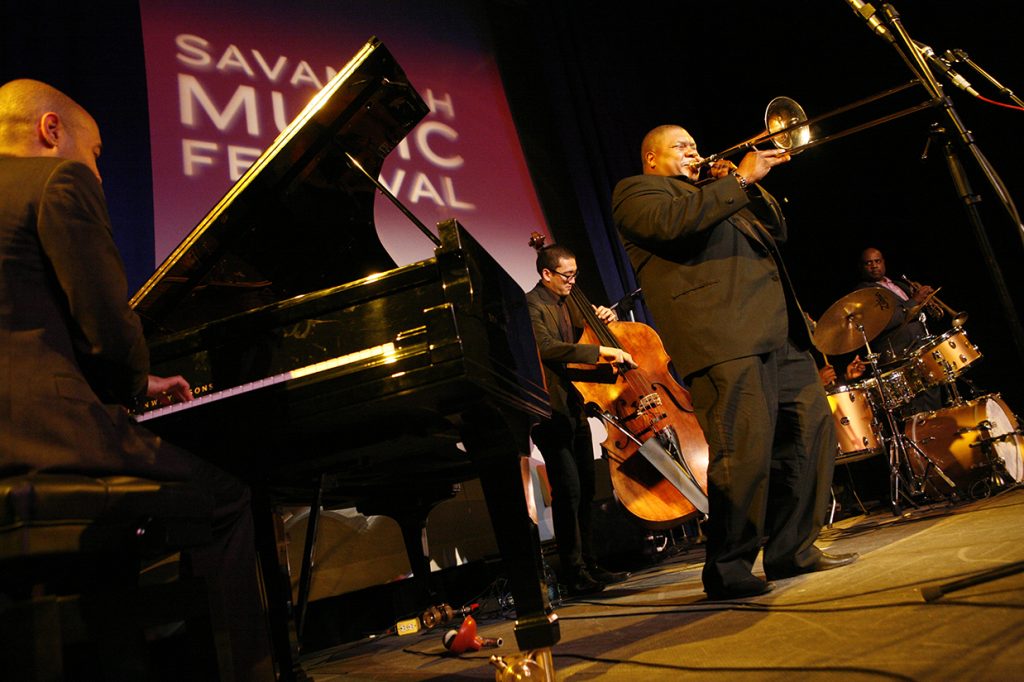 Men playing trombone, drums, standup bass and piano at Savannah Music Festival, winner of Best Festival in Best of Savannah 2023