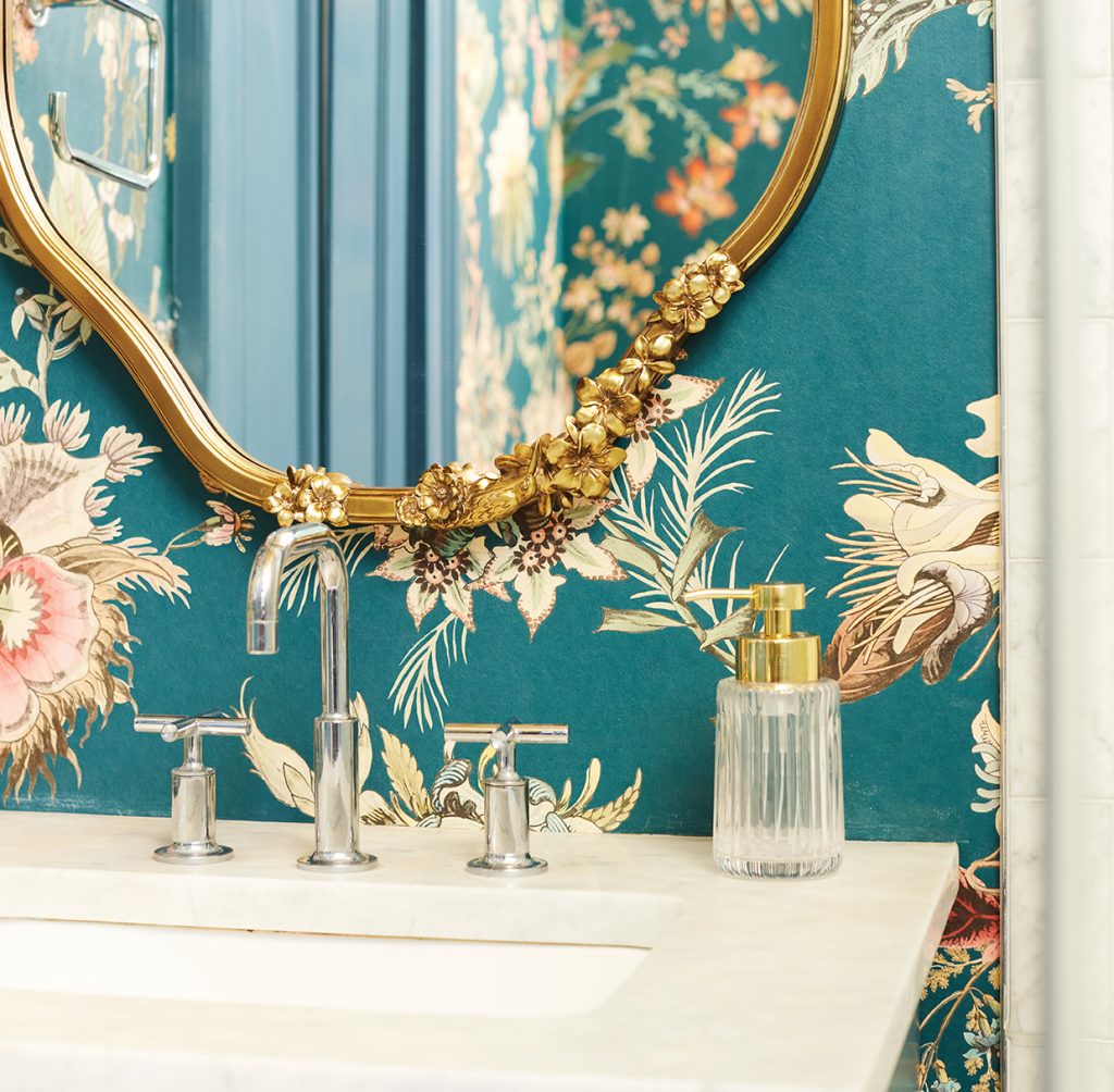 Bathroom sink with gold floral mirror and teal floral wallpaper