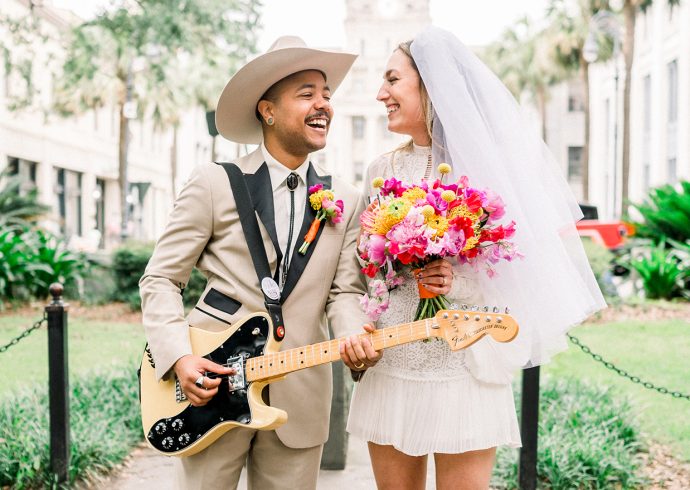 Bride holding bouquet and groom holding a guitar