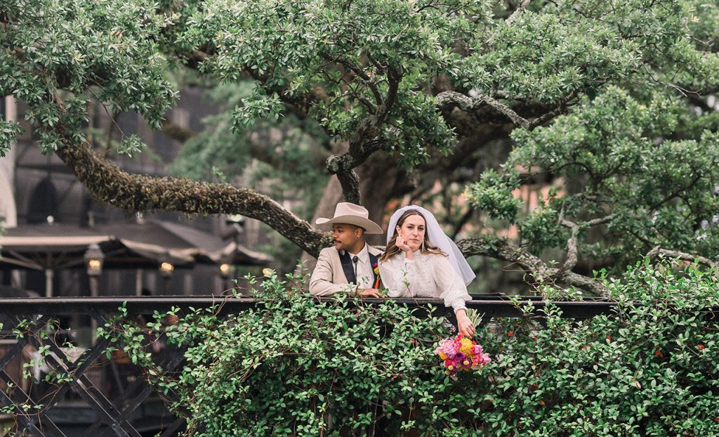 bride and groom standing beneath a live oak