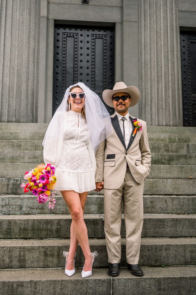 bride and groom wearing sunglasses and standing on steps