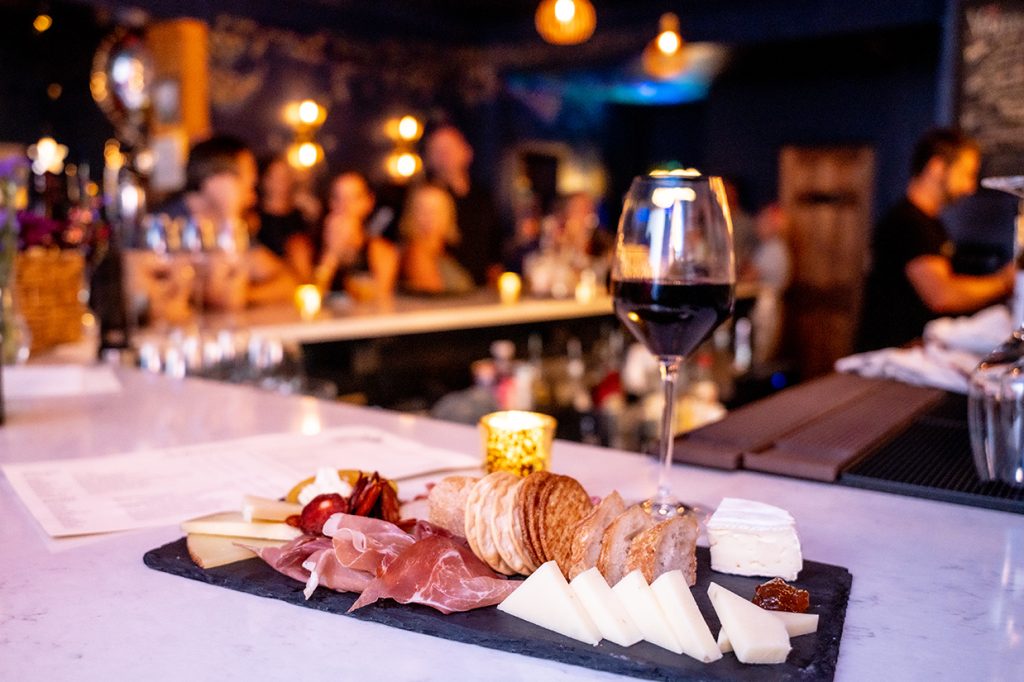 Charcuterie board and glass of red wine on a bartop at Best of Savannah Winner Sobremesa