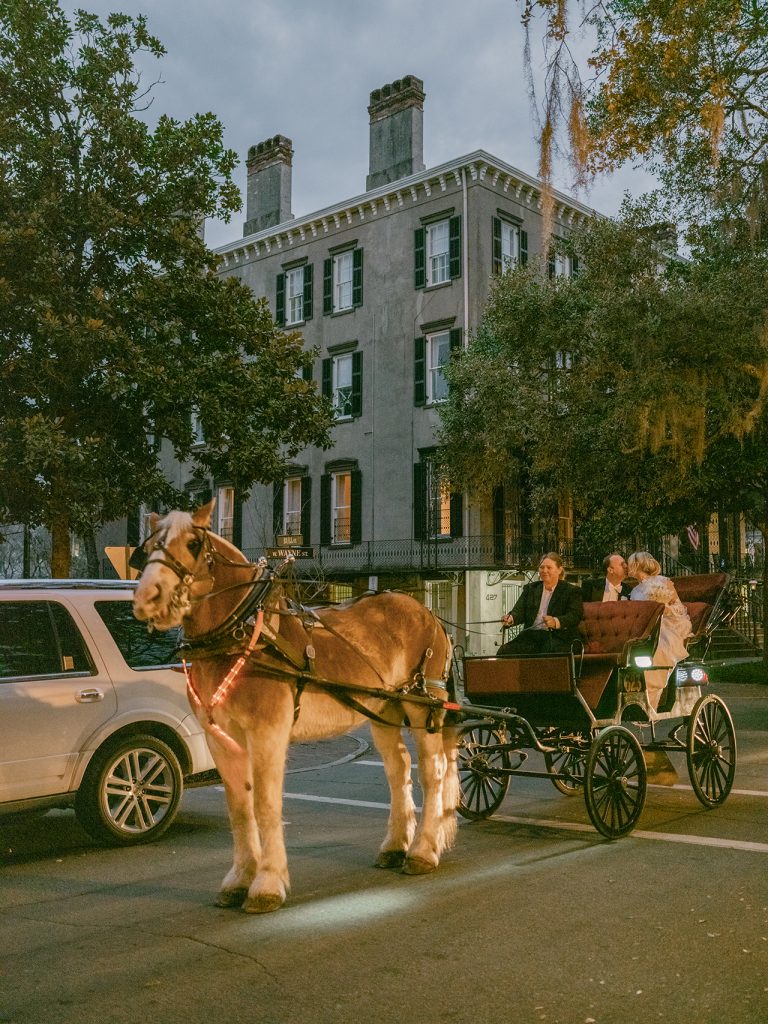 bride and groom riding in a horse-drawn carriage