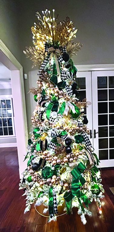 Christmas tree decorated with gold and emerald ornaments and bows